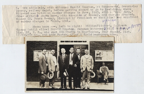 Bill Blizzard, Frank Keeney, and other United Mine Workers officials at railway depot before heading to trial for murder.  Typewritten annotation is by William C. Blizzard, and is attached to the photograph.