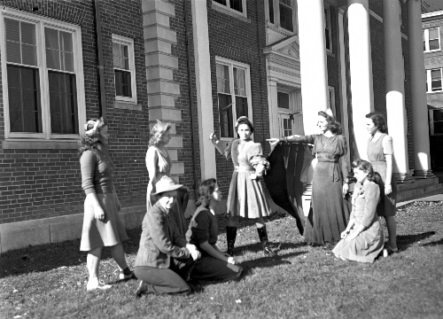 7.16.4; Students on campus, possibly practicing a play